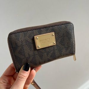 Michael Kors wristlet with built in wallet packets and change pocket.